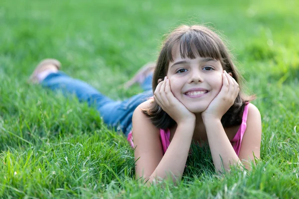 Portret dreaming dziewczyna w różowym na zielonej trawie — Zdjęcie stockowe