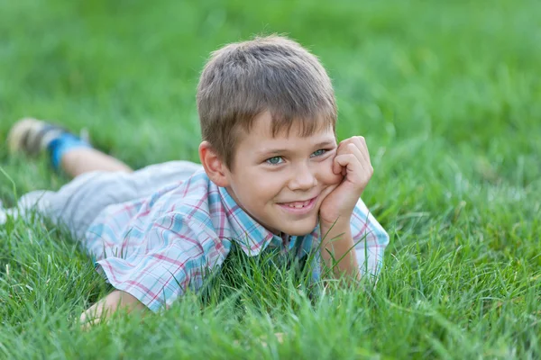Красивый мальчик на зеленой траве — стоковое фото