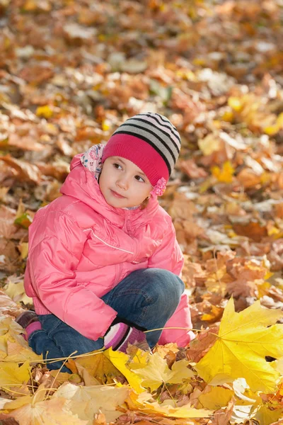 Pensive little girl in the autumn park — Stock Photo, Image