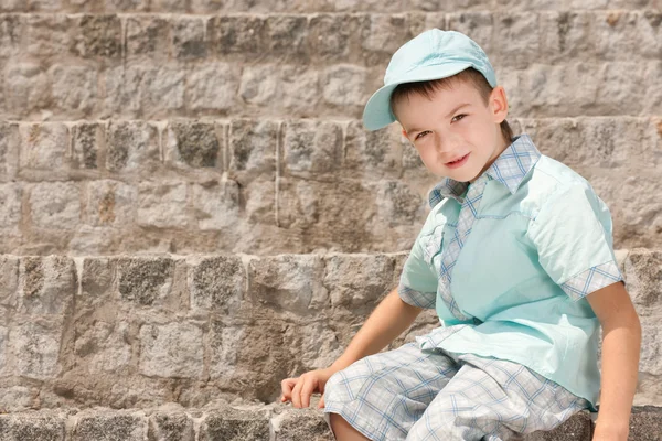 Мальчик на каменных ступеньках — стоковое фото