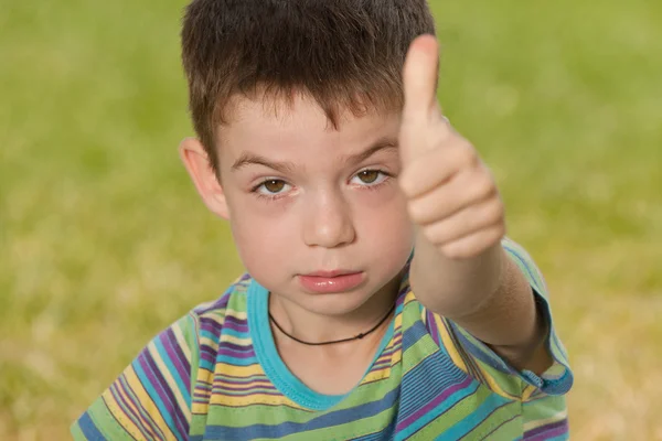 Злой мальчик с поднятым большим пальцем — стоковое фото