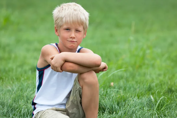 Красивый мальчик на зеленой траве — стоковое фото