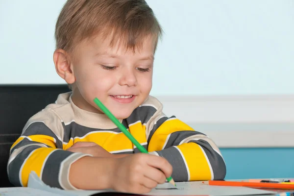 Kleiner Junge zeichnet am Schreibtisch — Stockfoto