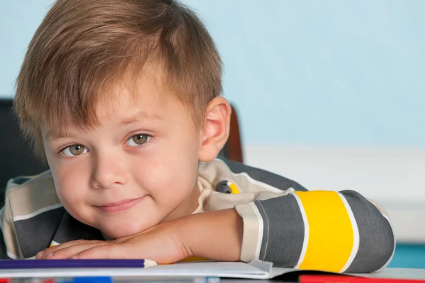 Porträtt av en leende pojke vid skrivbordet — Stockfoto