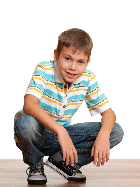 Uśmiechnięty chłopiec squating — Zdjęcie stockowe