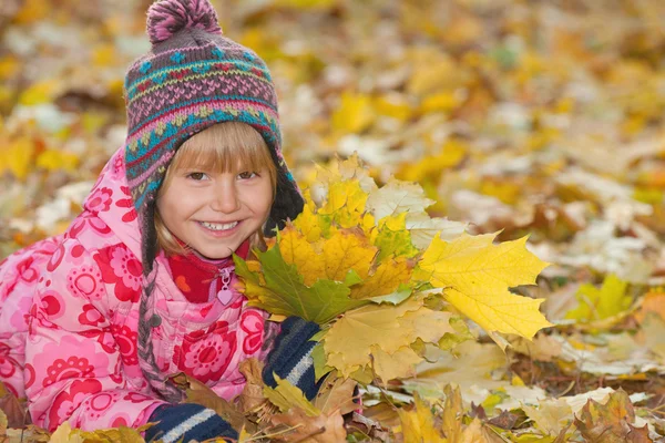 Niña sonriente con hojas amarillas —  Fotos de Stock