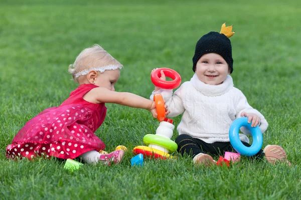 2 つの非常に小さな女の子が芝生で遊んでの肖像画 — ストック写真