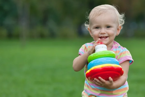 Glückliches kleines Mädchen mit einer Spielzeugpyramide — Stockfoto