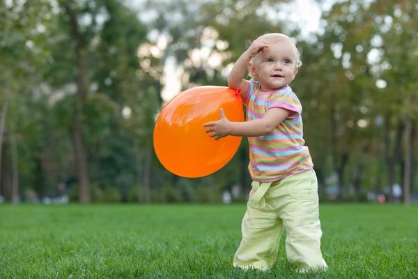 Malá dívka si hraje s ballon v letním parku — Stock fotografie