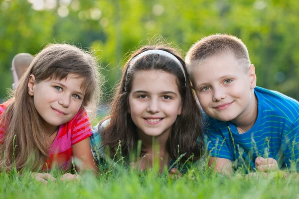 Three kids on the grass Stock Photo