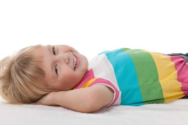 Glückliches kleines Mädchen auf dem weißen Teppich — Stockfoto