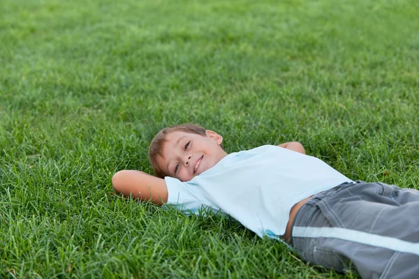 Glücklicher Junge auf dem grünen Gras — Stockfoto