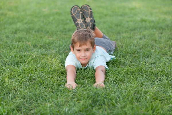 Улыбающийся мальчик на летнем лугу — стоковое фото