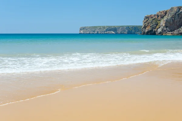 Praia de areia ensolarada com ondas ligeiramente — Fotografia de Stock