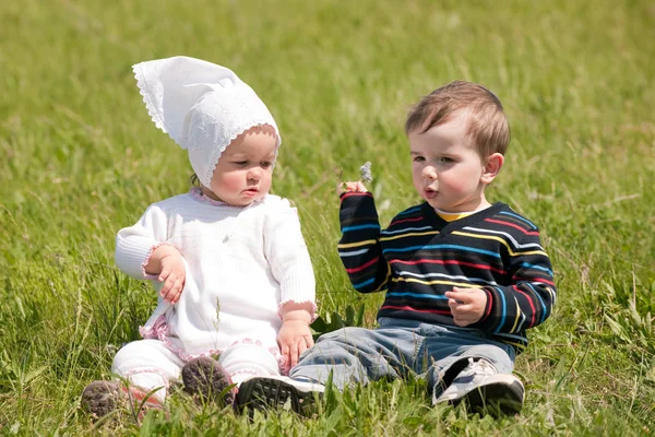 Duas crianças na grama verde — Fotografia de Stock