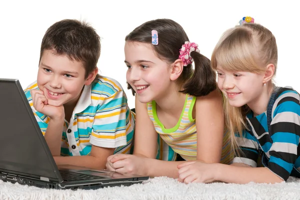 三个性格开朗的孩子使用的一台笔记本电脑 — 图库照片