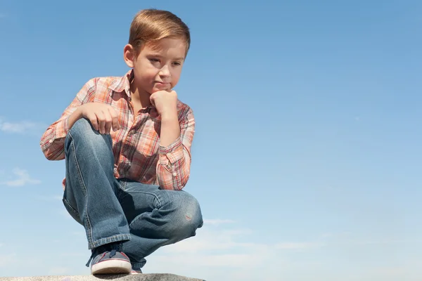 Handsome kid thinking against the sky — Stock Photo, Image