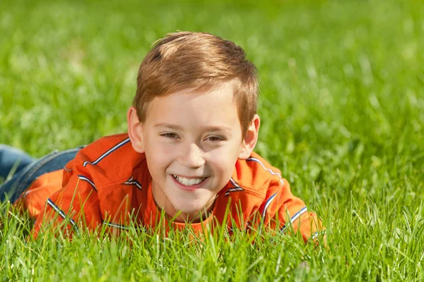 Смеющийся мальчик на траве — стоковое фото