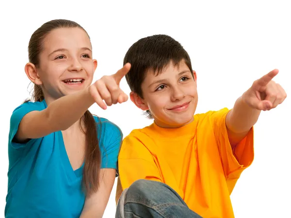 Smiling children pointing forward — Stock Photo, Image