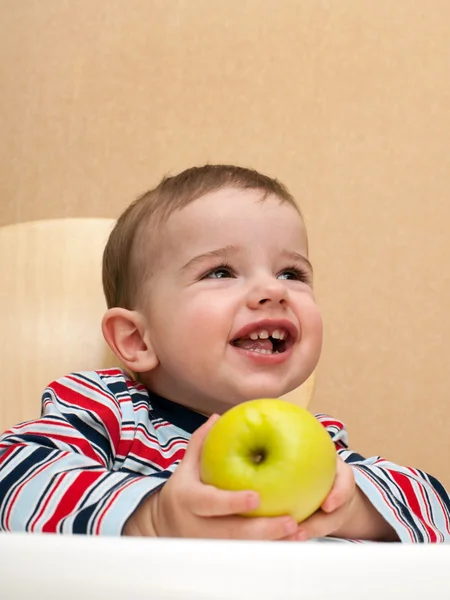 Laughing toddler holds an apple — Stock Photo, Image