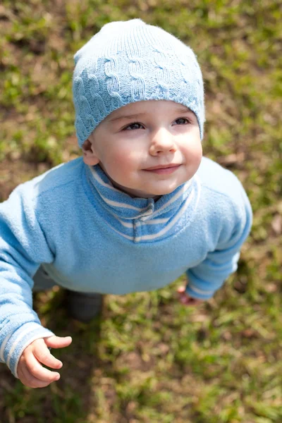 Portrait of a kid in blue walking in the spring meadow — Stock Photo, Image