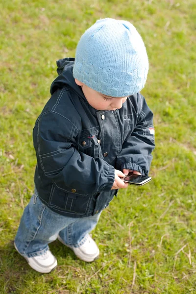 Criança em azul enviando SMS através do celular — Fotografia de Stock
