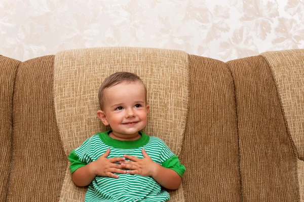 Menino sorridente no sofá — Fotografia de Stock
