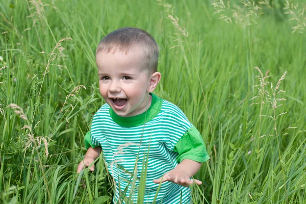 草の中で遊び心のある少年 — ストック写真