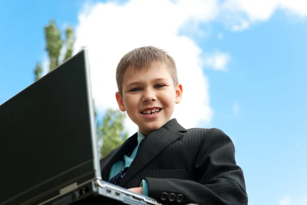 Boy with laptop studies outside — Stock Photo, Image
