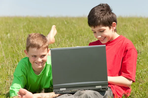 Twee vrienden met een laptop in de buitenlucht — Stockfoto