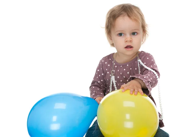 Little girl holding yellow and blue balloons — Stock Photo, Image