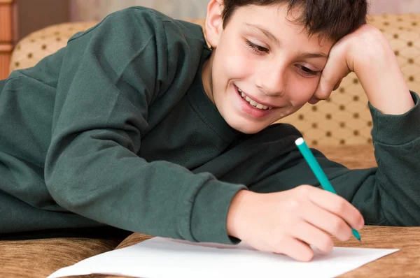 Usměvavý chlapec píše dopis — Stock fotografie