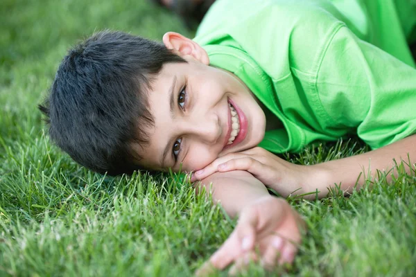 Lächelnder Junge im Grünen auf der Sommerwiese — Stockfoto