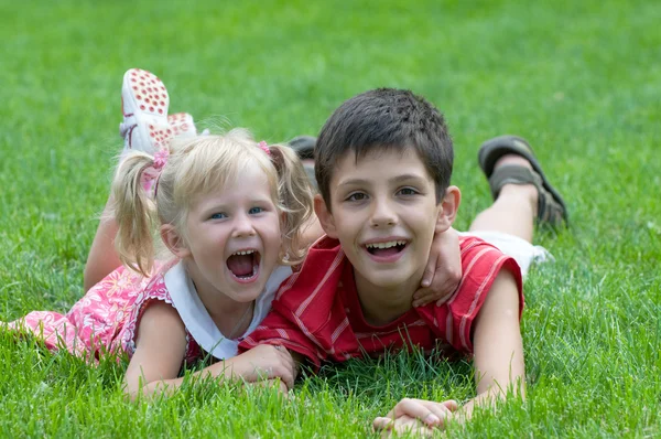 Lachende klein meisje en jongen in het park — Stockfoto