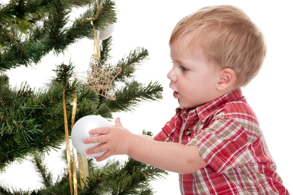 Маленький мальчик украшает новогоднюю елку — стоковое фото