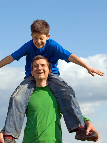 A man is handing his happy son outdoors — Stock Photo, Image