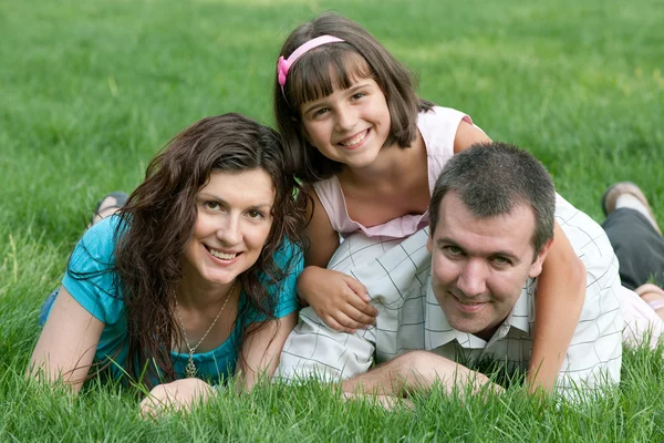 Šťastná trojčlenná rodina v parku — Stock fotografie