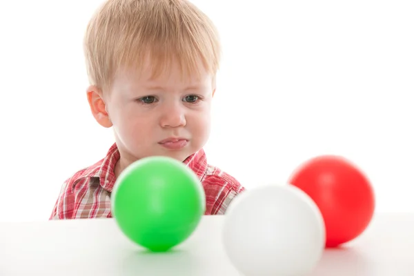 Confused kid looking at balls — Stock Photo, Image