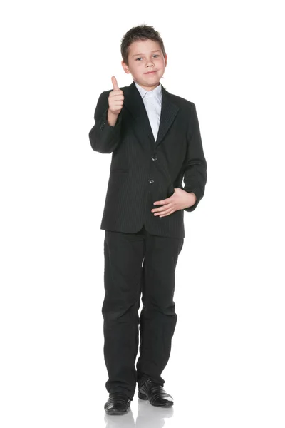 Happy kid i kostym håller tummen upp — Stockfoto