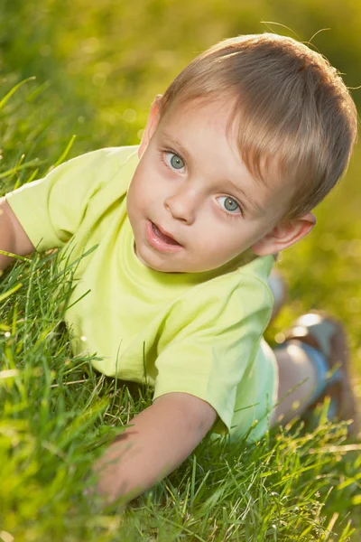 Divertente ragazzino sdraiato sull'erba — Foto Stock
