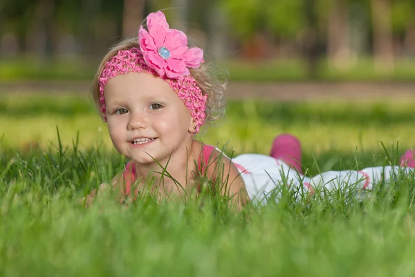 Glad liten flicka på det gröna gräset — Stockfoto