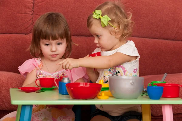 Små flickor spela vid bordet — Stockfoto