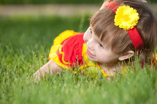 Usmívající se dívka na zeleném trávníku — Stock fotografie
