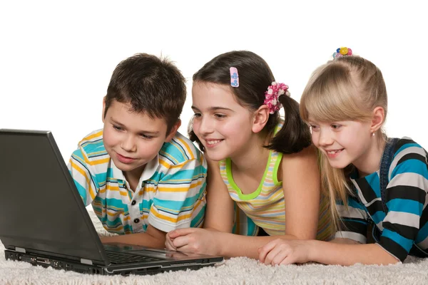 Kinderen met laptop op het tapijt — Stockfoto