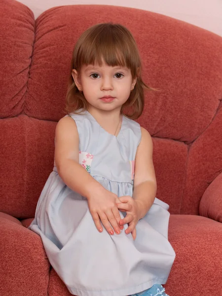 Allvarliga lilla flickan i soffan — Stockfoto