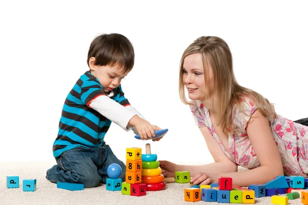 Spela på mattan mor och son — Stockfoto