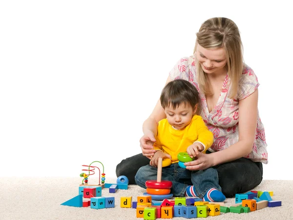 Matka a syn na koberci s hračkami — Stock fotografie