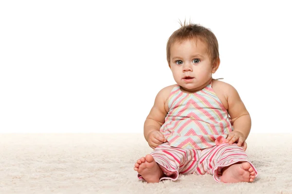 女の赤ちゃんは、カーペットの上に座っています。 — ストック写真