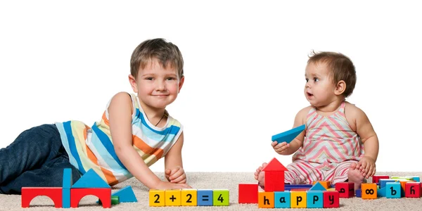Smiling boy and a baby girl with blocks — Stock Photo, Image