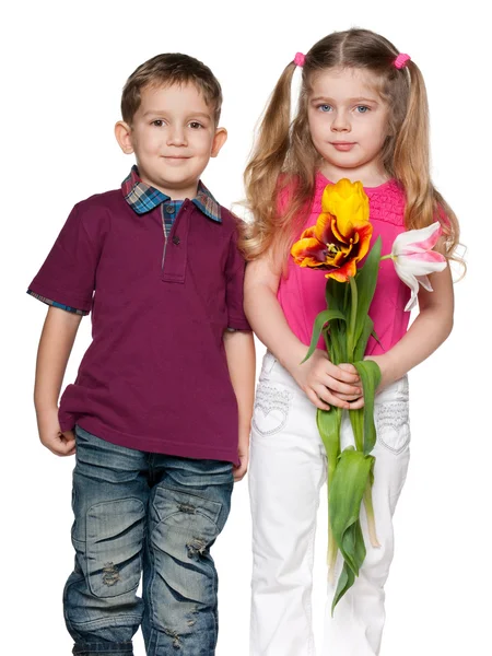 Усміхнений хлопчик і красива дівчина з квітами — стокове фото